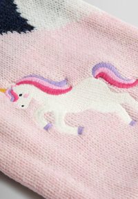 Un material tricotat roz prezintă un unic de brodat alb cu o coamă multicoloră, accentuată de detalii în violet și roz.