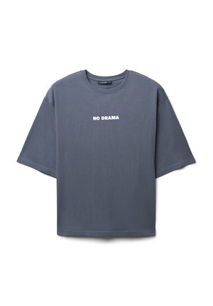 T-shirt in cotone grigio con un fit rilassato, collo rotondo e maniche corte. Presenta un audace testo bianco "NO DRAMA" sulla parte anteriore.