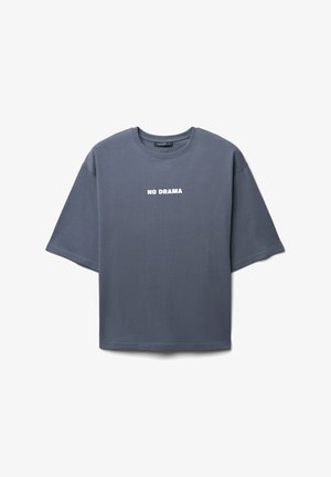 T-shirt in cotone grigio con un fit rilassato, collo rotondo e maniche corte. Presenta un audace testo bianco "NO DRAMA" sulla parte anteriore.