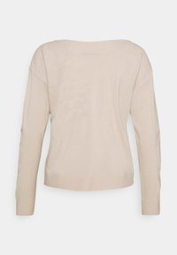 Beige gebreide trui met een ronde hals, lange mouwen en geribde manchetten. Gladde textuur met een iets losse pasvorm, eenvoudig ontwerp en geen patronen.