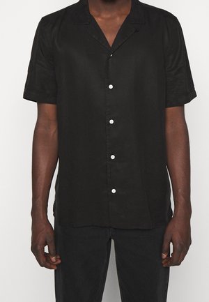 Zwart shirt met korte mouwen van soepele stof, met een notch-kraag en vijf witte knopen aan de voorkant, met opgerolde mouwen.