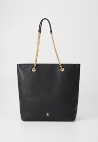 Black faux leather tote bag with gold chain straps and a minimalist design. Features a small gold logo at the bottom center.