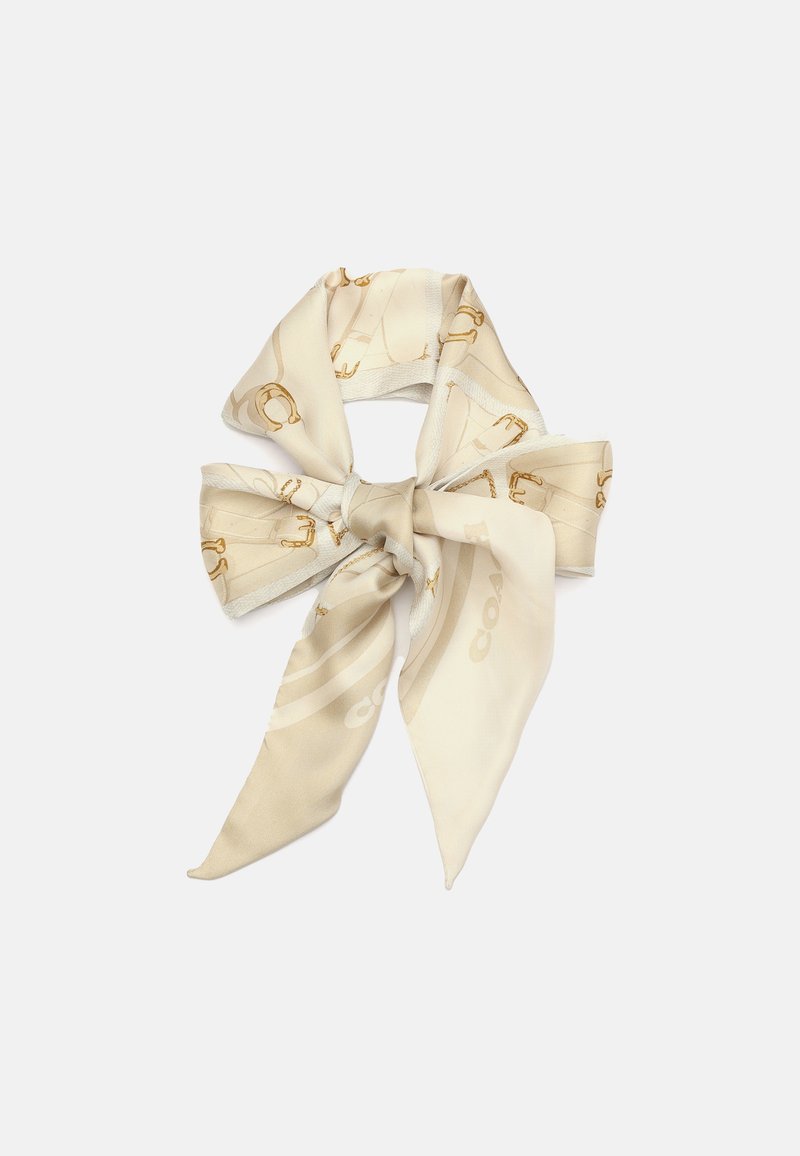 Écharpe en soie beige avec un design de nœud, ornée d'accents et de motifs dorés imprimés, mettant en valeur une texture lisse et un drapé élégant.