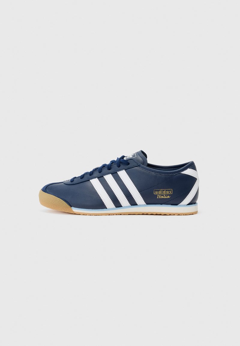 Mørkeblå sneaker med hvide striber og gummisål. Har et slankt design, glat lædermateriale og "adidas Italia" logo på siden.