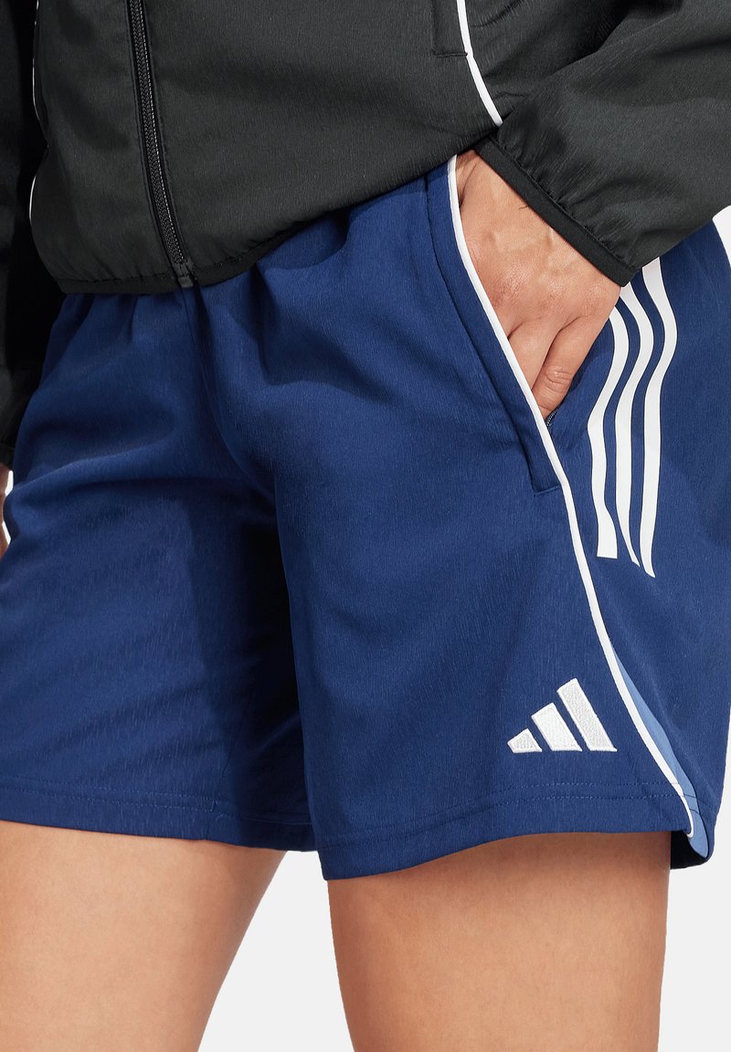 Navy sportshorts van lichtgewicht materiaal, met witte zijstreepjes en subtiele branding aan de zoom. Glad textuur, normale pasvorm.