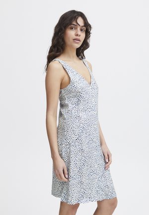 Robe sans manches en tissu léger avec un décolleté en V. Le design présente un motif moucheté dans des tons de bleu et de blanc, avec un ourlet évasé.