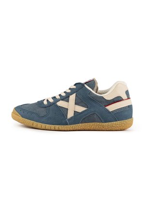 Zapatillas de ante azul con acentos crema, diseño de cordones, suela texturizada y un logotipo en forma de X. Presenta un collar acolchado y franjas de contraste.