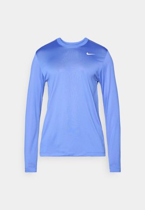 Μακρυμάνικη μπλούζα από λείο μπλε ύφασμα, με στρογγυλή λαιμόκοψη και μικρό λευκό λογότυπο στο στήθος. Απλός, μινιμαλιστικός σχεδιασμός.