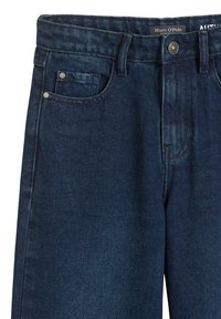 Ciemnoniebieskie dżinsy z denimu, z zapięciem na guziki z przodu, szlufkami na pasek oraz małą kieszonką na monety w prawej przedniej kieszeni.