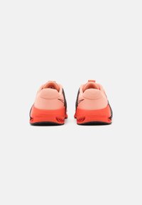 Les chaussures de sport en mesh noires et corail présentent un dos texturé, un détail de logo et un talon rembourré avec une semelle en caoutchouc durable.