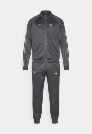 Gray Nike tracksuit featuring a zippered jacket with a logo, slim-fit pants with logo, and white side stripes on sleeves and legs.