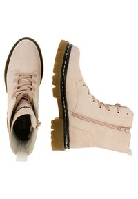 Botas de ante beige con cordones y cremallera lateral, cuello acolchado, suela resistente en negro y marrón, y tirador blanco en el talón.