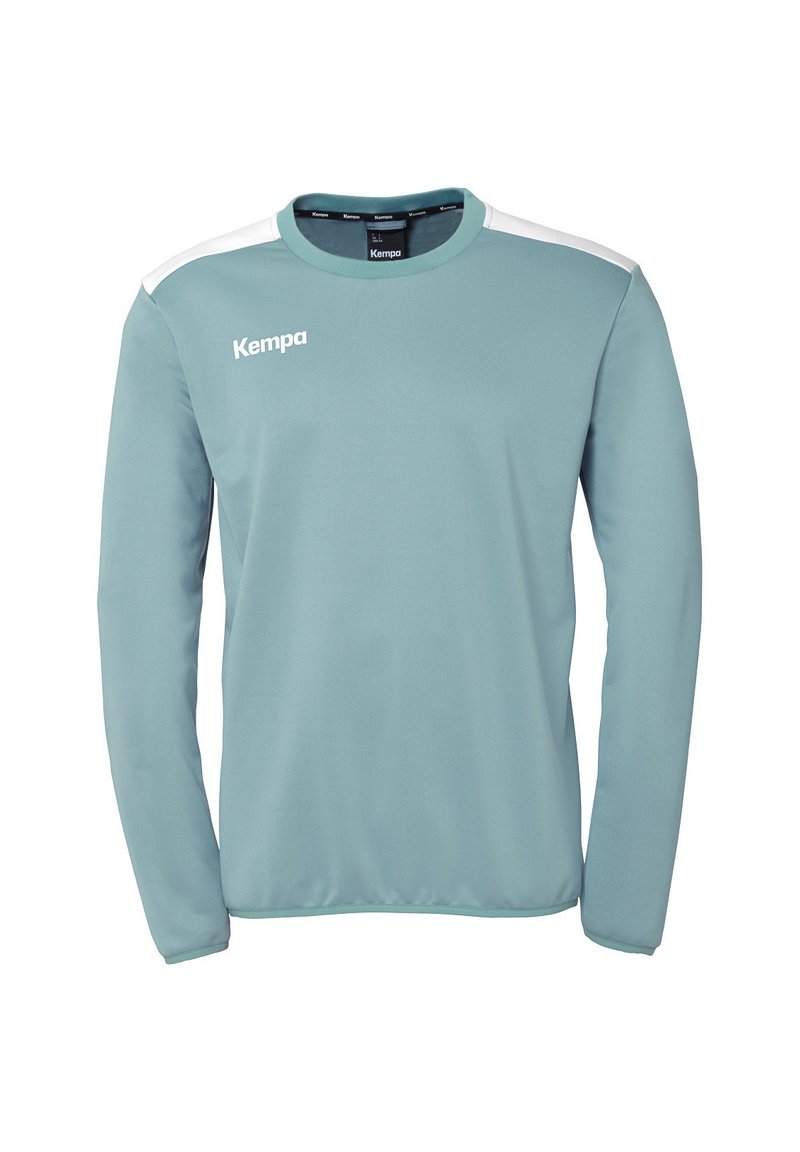 Lichtblauwe sportshirt met lange mouwen van een gladde stof. Bevat witte schouderaccenten en het "Kempa" logo op de voorkant.