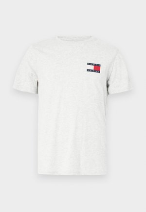 Baltas trumpomis rankovėmis marškinėlis su apvalia iškirpte ir mažo Tommy Jeans logotipu, kuriame yra raudonos, baltos ir mėlynos spalvos, kairėje krūtinės pusėje.