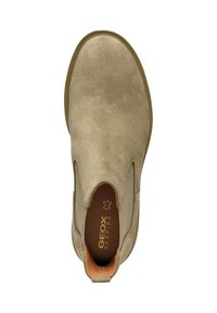 Stivale alla caviglia in suede beige con pannelli laterali elastici e suola in gomma, caratterizzato da una texture liscia e un design minimalista.