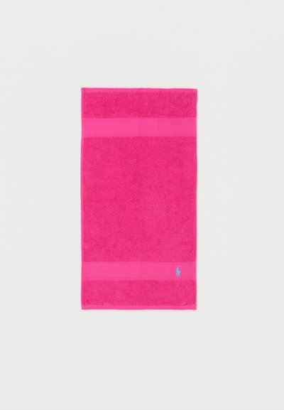 Bright pink rectangular towel with a small light blue embroidered logo near the bottom edge, laid flat on a white surface.