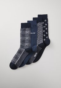 Fem par sokker i varierende nuancer af mørkeblå. Mønstre inkluderer geometriske designs og blomsterdetaljer. Materialet ser blødt og tekstureret ud.