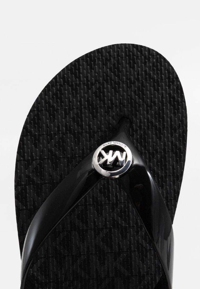 Schwarze Flip-Flop-Sandale mit glänzenden Riemen, einem strukturierten schwarzen Fußbett mit einem dezenten Muster und einem silbernen Logoakzent am Riemen.