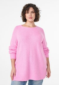 Ružový oversize sveter s okrúhlym výstrihom, rebrovanými manžetami a vzorovaným pleteným vzorom. Voľne sa zvažuje na tele.
