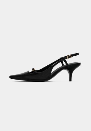 Schwarze Slingback-Pumps mit spitz zulaufender Zehenpartie, niedrigem, geschwungenem Absatz und kleiner goldener Schnalle am vorderen Riemen sowie am Knöchelriemen.