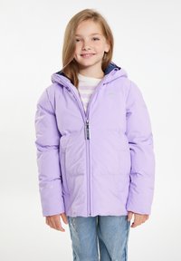Giacca imbottita lavanda con cappuccio, chiusura frontale con zip, tasche laterali e logo sulle maniche. Indossata sopra una camicia a righe e jeans blu.