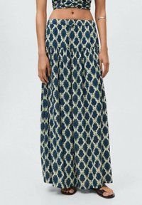 Maxi skirt in navy and cream with a geometric pattern. Made of lightweight fabric, featuring a pleated design and an elastic waist.