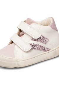 Sneaker bianco e rosa con due cinturini in Velcro, dettagli in suede e lato glitterato. Suola in gomma testurizzata con una presa a motivo.