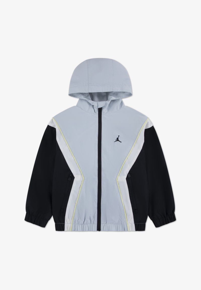 Ανοιχτό γκρι αντιανεμικό μπουφάν με μαύρα μανίκια, λευκές και νέον κίτρινες λεπτομέρειες, κλείσιμο με φερμουάρ, ρυθμιζόμενη κουκούλα και επένδυση από δίχτυ.