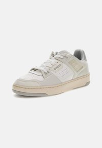 Białe skórzane sneakersy z teksturowanym czubkiem, gładką cholewką, perforowanymi akcentami i jasnoszarymi detalami. Posiadają wyściełany kołnierz i gumową podeszwę.