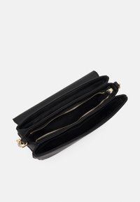 Clutch bag in pelle nera con design strutturato. Presenta due scomparti con cerniera e hardware in tonalità oro per la chiusura. Texture liscia.