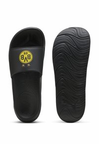 Sorte slidesandaler med en bred rem, der har et gult cirkulært logo og to stjerner. Tekstureret sort gummisål med bølgeformet mønster.