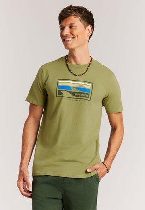 Olijfgroene T-shirt met korte mouwen, voorzien van een rechthoekige afbeelding in blauw, beige en wit. Zachte stof, ontspannen pasvorm.