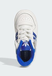 White sneaker with blue accents, featuring perforated toe, white laces, and a plush blue collar. Logo visible on the tongue.
