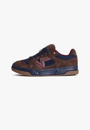 Brown suede sneakers with navy accents, featuring a burgundy logo, round laces, and a textured rubber sole for grip.