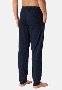 Tmavě modré pyžamové kalhoty z lehké látky s abstraktním vzorem. Elastický pas, dvě boční kapsy a rovný střih nohavic.