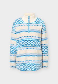 Pull polaire crème à manches longues avec motifs géométriques et en zigzag bleus, col montant côtelé et fermeture éclair bleue à un quart.
