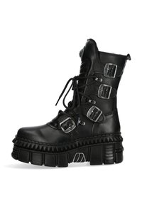 Black leather knee-high boot with multiple silver buckles, lace-up front, chunky textured sole, and a rugged design.
