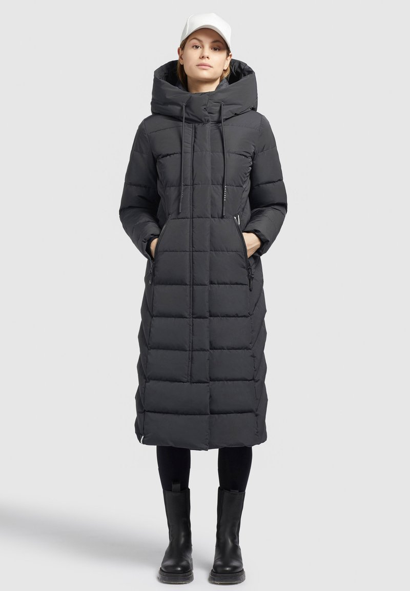 Giacca a vento nera con un lungo design trapuntato, colletto alto e tasche laterali. Presenta una chiusura con zip ed è realizzata in materiale isolante.