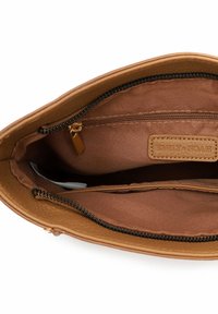 Interno di una borsa in pelle color cuoio con fodera in tessuto marrone, due scomparti e una tasca con cerniera e dettagli in metallo dorato.