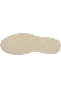 Shoe sole in light beige with textured grip patterns, rounded shape, and molded contours for flexibility. No visible branding or accents.