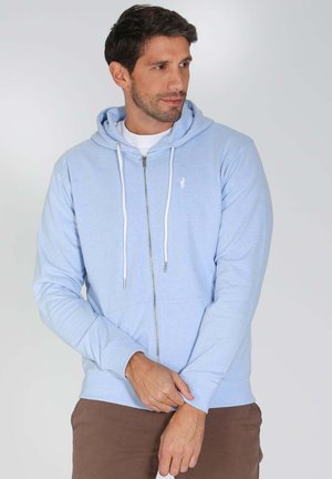 Hoodie zippé bleu clair en tissu doux ; possède une poche kangourou, des cordons de serrage et un petit logo brodé sur la poitrine.