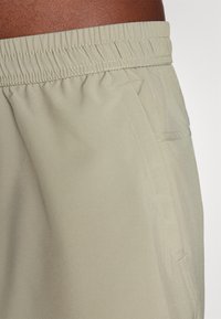 Khaki shorts met een elastische tailleband, gemaakt van gladde stof, met zijzakken en een subtiele glans.
