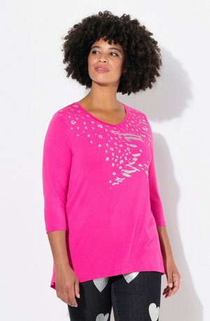 T-shirt à manches longues rose vif avec décolleté arrondi, présentant un motif léopard argenté et un ourlet courbé pour plus de détail.