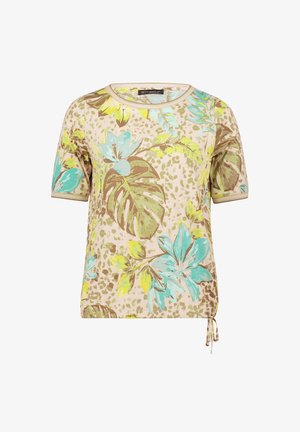 Beige shirt met korte mouwen, grote turquoise en gele bloem- en bladpatronen, ronde halslijn en zijstrikdetail.