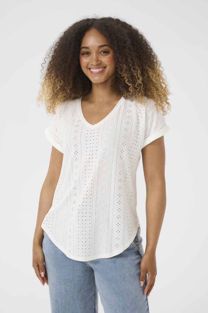 Witte korte mouwen, V-hals top met een oogjesdesign, intricaten patronen, gestructureerd oppervlak en een ontspannen pasvorm, gecombineerd met lichtblauwe jeans.