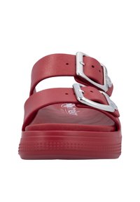 Red rubber sandals featuring two adjustable straps with silver buckles. Textured footbed and a slight platform sole with star-patterned detailing.