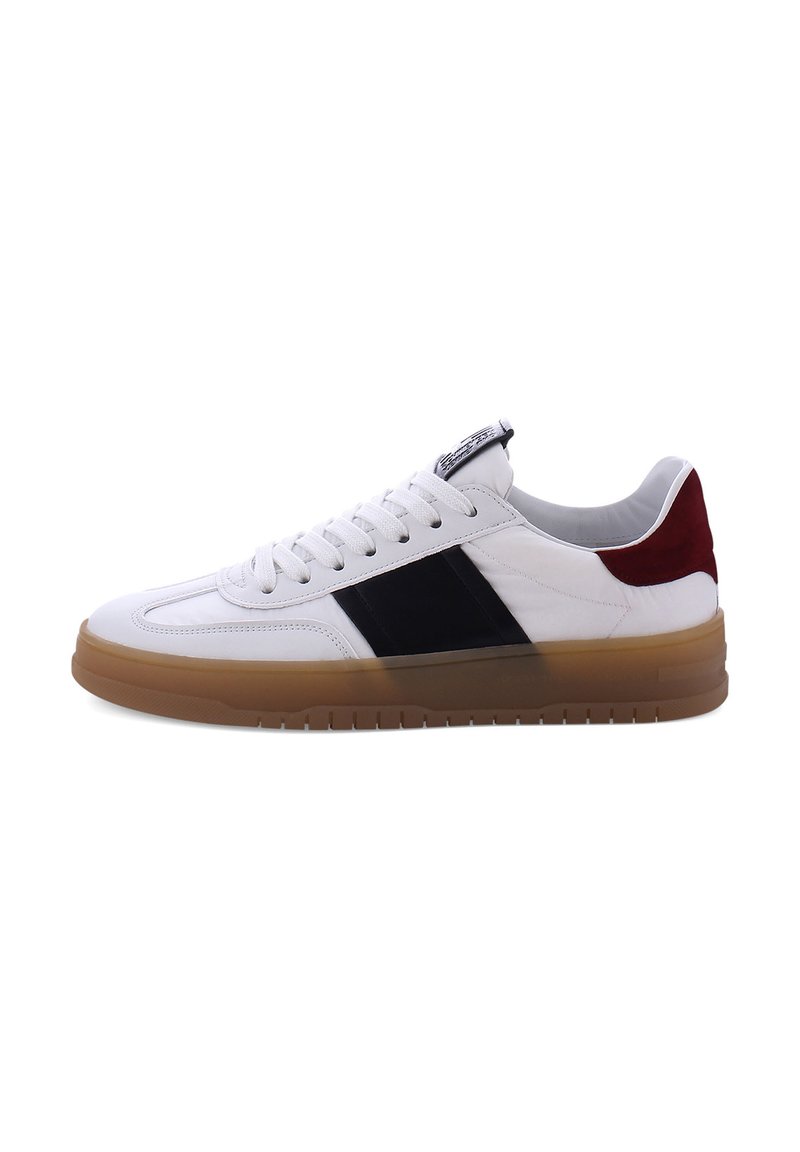 Witte sneaker met zwarte en bordeauxrode accenten, gemaakt van leer en suède, ronde neus, witte veters en een gumrubberen zool.