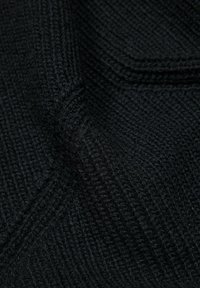 Tissu en tricot noir avec une texture à côtes denses et un motif de tissage visible, montrant des plis et des détails de texture douce.