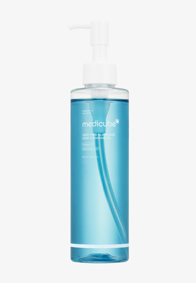 Bouteille en plastique transparent avec un distributeur blanc, remplie d'huile nettoyante bleue. L'étiquette indique "Medicube Zero Pore Blackhead Deep Cleansing Oil" et les ingrédients.