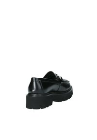 Zapato de cuero negro con un diseño elegante, punta redondeada, acento decorativo de lazo y suela de goma gruesa para mayor altura y tracción.